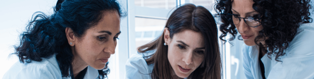 Scientists discussing research in lab setting — representing Hello Bio’s commitment to affordable, high-quality life science tools